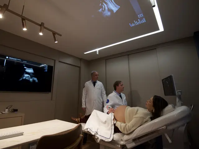 Dr. Thiago Martinelli e Dr. Bernardo Sperandio durante um exame de ultrassom, com a imagem do bebê projetada no teto da sala
