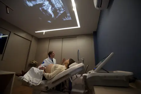 Sala de exame com a projeção do ultrassom no teto